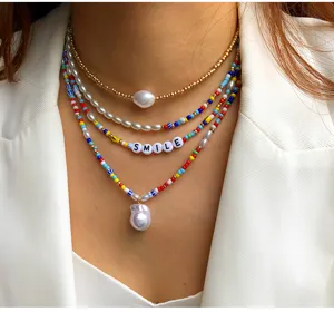 Collana a più strati di perle irregolari e perline colorate con ciondolo di lettere.