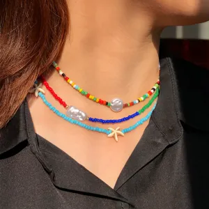 Primo piano della collana girocollo bohémien multistrato di perline colorate con conchiglie.