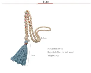 Lunga collana di perline in legno con nappa blu e conchiglie, stile boho, dettaglio.