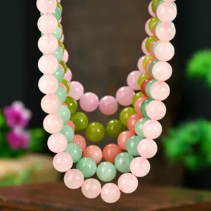 Close-up detail shot of natural stone beaded necklace showing smooth bead texture and rich layers.