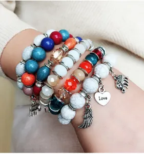 Primer plano detallado de pulseras de cuentas boho coloridas apiladas con dijes de metal.