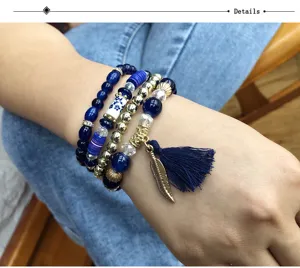 Vista detallada del conjunto de pulseras de cuentas bohemias multicapa con borla y pluma.