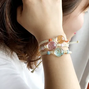Bracciale in canapa intrecciata a mano con ciondoli in resina e fiori secchi in stile boho.
