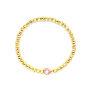 Détail d'un bracelet de perles bohème plaqué or 18 carats avec breloque œil porte-bonheur rose.