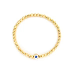 Vue détaillée d'un bracelet en perles dorées bohème avec un porte-bonheur œil bleu