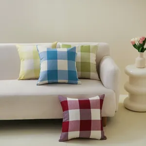 Klassische Leinenkissen mit Karomuster in verschiedenen Farben auf einem weißen Sofa