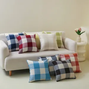 Bunte karierte Zierkissen, die elegant auf einem weißen Sofa in einem hellen Raum liegen