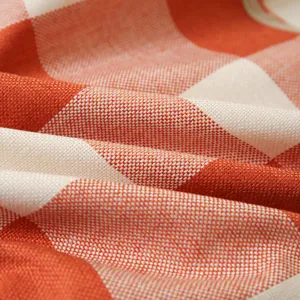 Klassische Texturdetails aus orangefarbenem und cremefarbenem Kissenbezug aus Leinen