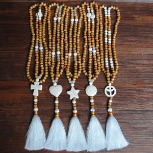 Lunga collana di perline di legno fatta a mano con nappina bianca e ciondoli in pietra.