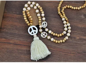 Long collier pull en perles de bois boheme avec pendentifs signe de paix et beau pompon.