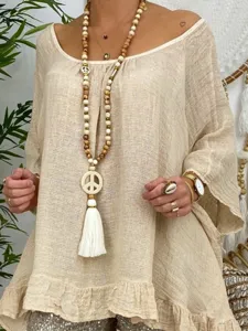 Gros plan sur le collier de perles en bois boheme avec pendentif signe de paix, detail design.