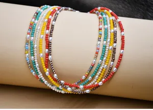 Primer plano detallado de la gargantilla choker multicapa con cristales coloridos y perlas.