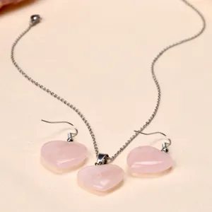 Detailed view of the natural rose quartz heart necklace and matching hook earrings set.