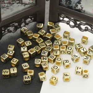 Nahaufnahme goldener quadratischer Acryl-Buchstabenperlen, ideal fur DIY-Schmuck und Armbänder.