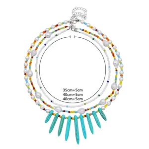 Collana di perle multilivello con perle finte e ciondoli turchesi, design chic.