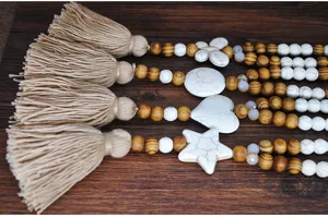 Collana lunga in perle di legno stile bohémien con ciondolo turchese bianco e nappa.