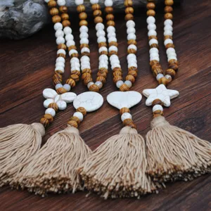 Lunga collana girocollo boho con perline in legno e nappa, ciondolo stella e cuore in turchese.