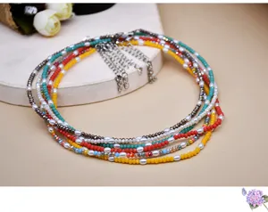 Detalles en primer plano del collar gargantilla multicapa de cristal y perlas con cadenas.