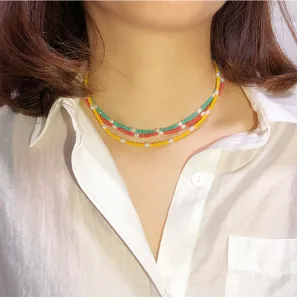 Primer plano detallado de un collar gargantilla multicapa con cuentas y perlas.