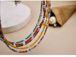 Vista detallada del elegante collar choker multicapa con cristales coloridos y finas perlas.