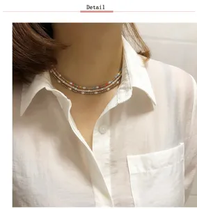 Primer plano de los detalles del collar choker multicapa de cristal de colores y perlas.