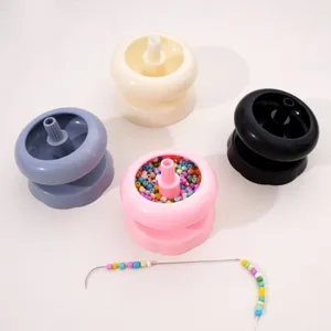 Détails du kit de bol toupie à perles en plastique coloré et aiguille courbée pour bijoux.