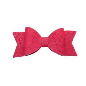 Close-up detail of a bright pink faux leather bowknot accessory with textured finish.