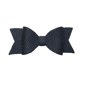 Black faux leather bow detail shot showing fine texture and multi-layer bow design.