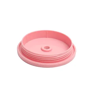 Pink plastic tumbler lid detail showing internal threads and center straw hole for cups.