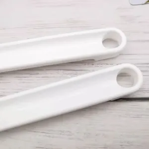 Primer plano detallado del mango de cepillo de bano de plastico blanco con agujero.