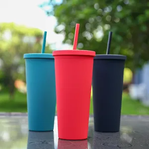 Detailansicht bunter doppelwandiger Plastikbecher mit flachen Deckeln und passenden Trinkhalmen.