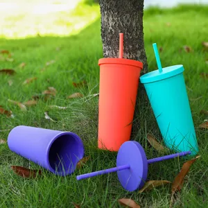 Doppelwandiger Kunststoff-Strohbecher Detailansicht bunter Becher mit Deckeln im Gras.