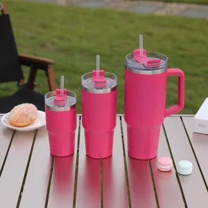Close-up of pink stainless steel insulated tumbler set with straw and handle for travel.