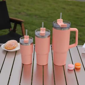 Pink stainless steel tumbler set with straw and handle for car and outdoor travel use.
