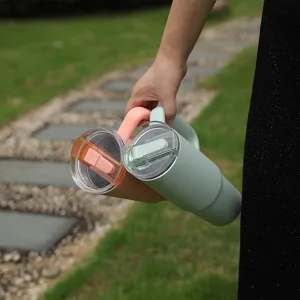 Outdoor stainless steel tumbler detail showing dual-drink lid and portable handle design.