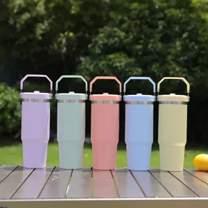 Detailed outdoor scene showcasing five pastel insulated tumblers with foldable handles on a table.