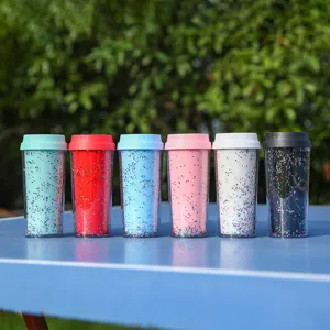 Primer plano de vasos de plástico coloridos de doble pared con lentejuelas brillantes.
