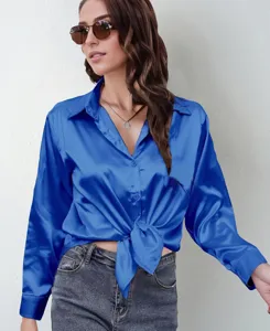 Close-up detail of women's blue satin long sleeve shirt featuring elegant front tie knot.