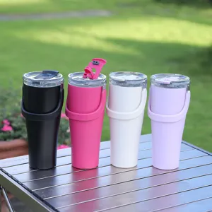 Detail shot of four colorful stainless steel insulated tumblers with handles on outdoor table.