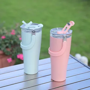 Stainless steel vacuum insulated tumbler with folding handle and straw lid for outdoor use.
