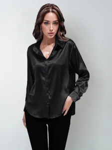 Close-up view of elegant black satin long sleeve button-down shirt on model, smooth fabric.