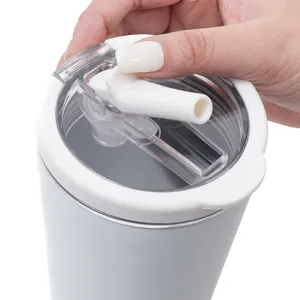 Dettaglio tazza termica in acciaio inossidabile con coperchio a doppia bevuta e cannuccia esterno.