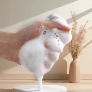 Primo piano dettagliato di densa schiuma detergente bianca spremuta a mano per cucina.