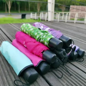 Vue détaillée de parapluies pliables colorés disposés sur une terrasse en bois.