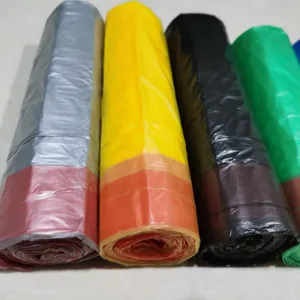 Primo piano dettagliato di sacchi spazzatura colorati con coulisse, rotolati ordinatamente.
