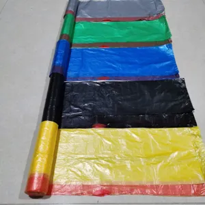Primo piano di sacchi della spazzatura multicolori con coulisse srotolati e colori vivaci.
