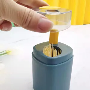 Detailed closeup view of automatic press type toothpick dispenser mechanism in use.