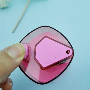 Detail view of the pink plastic automatic toothpick dispenser button press mechanism close up.