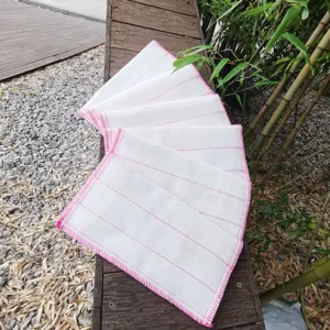Detailansicht von weißen Spültüchern mit pinkem Rand, saugfähiges Material für Küche.