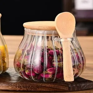 Glazen voorraadpot met houten deksel en lepel voor droog voedsel, thee en specerijen.